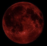 a red moon is seen in the night sky